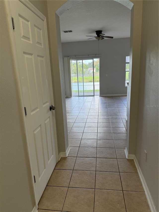 hallway with light tile patterned floors and a textured ceiling