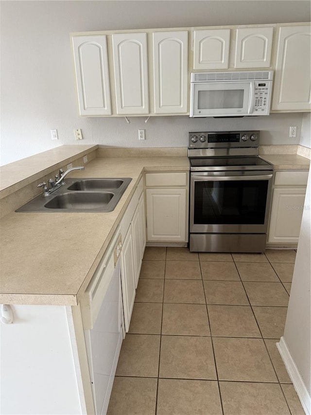 kitchen featuring white cabinets, white appliances, sink, and light tile patterned floors