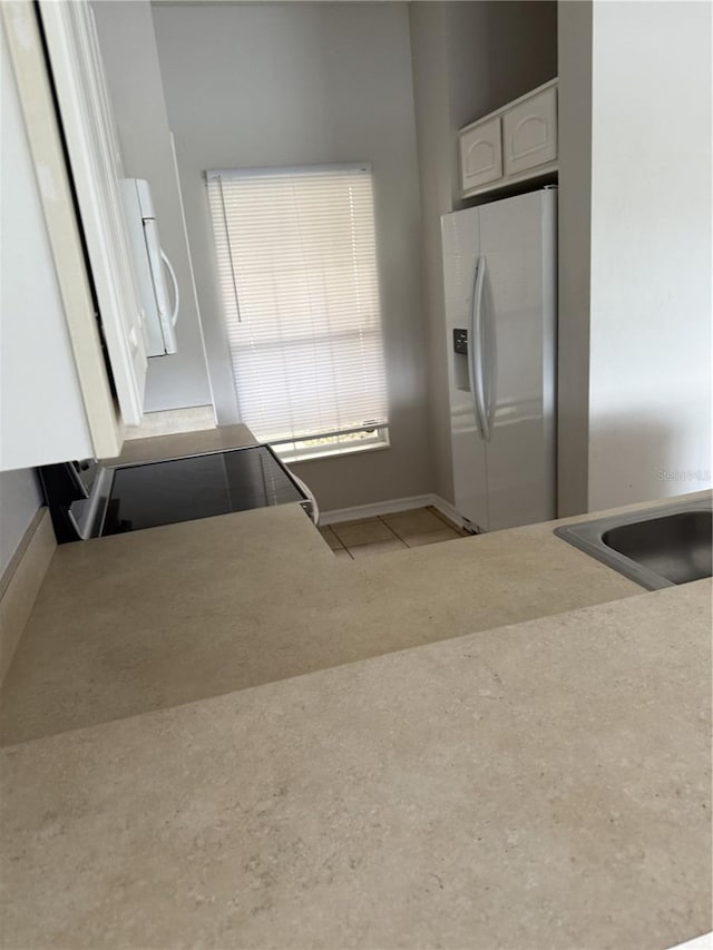 kitchen with white cabinets and white appliances