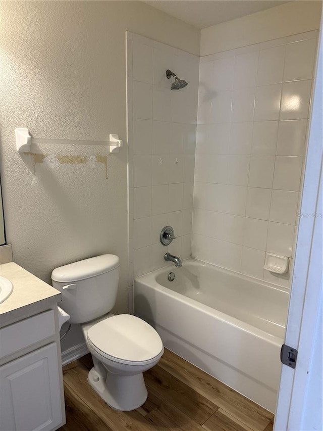 full bathroom featuring tiled shower / bath, toilet, vanity, and hardwood / wood-style flooring