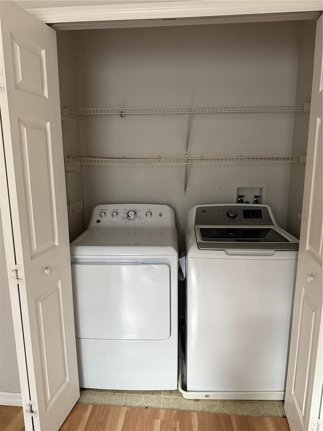 washroom featuring separate washer and dryer and light hardwood / wood-style floors