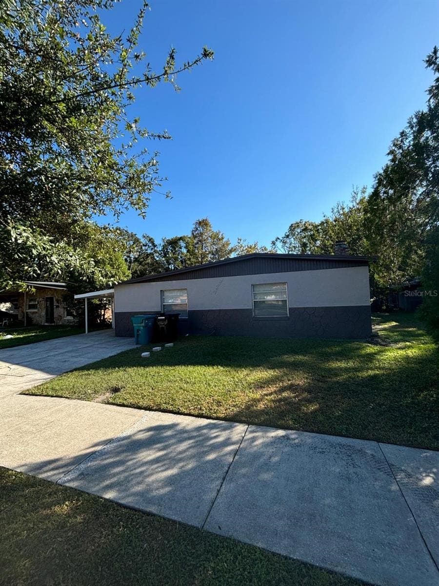 view of front of home featuring a front lawn and a carport