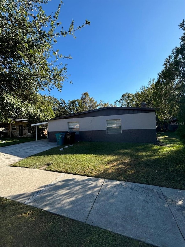 view of front of home featuring a front lawn and a carport