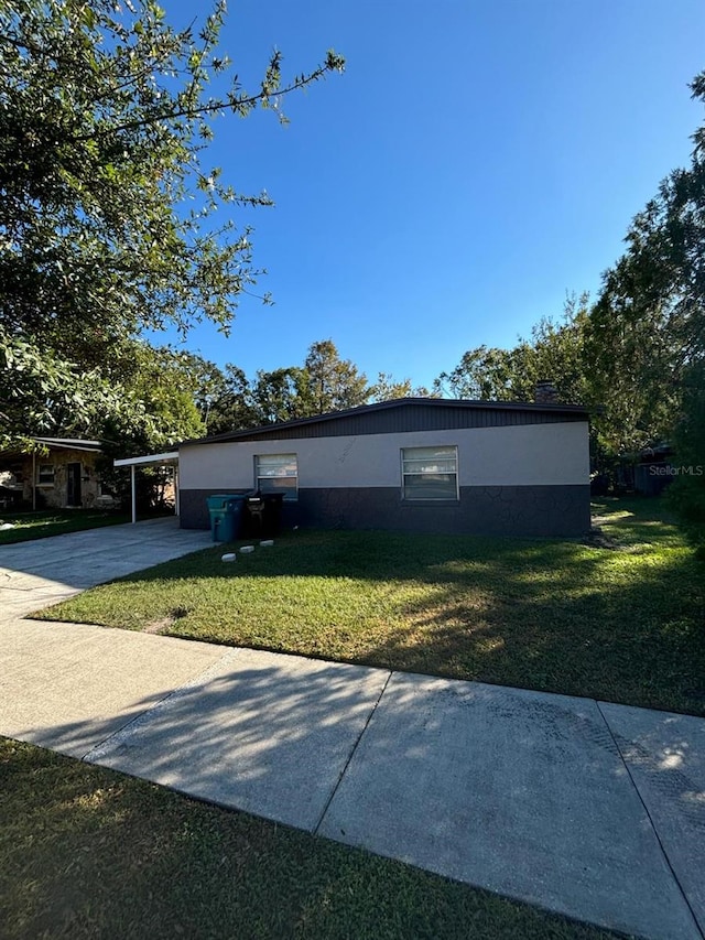 view of front of house featuring a front lawn and a carport