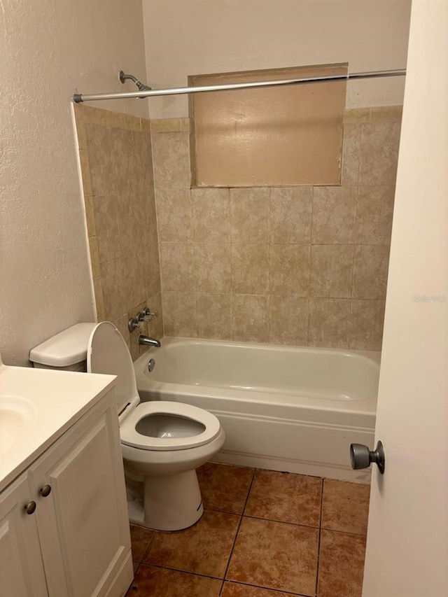 full bathroom with tile patterned flooring, vanity, tiled shower / bath combo, and toilet