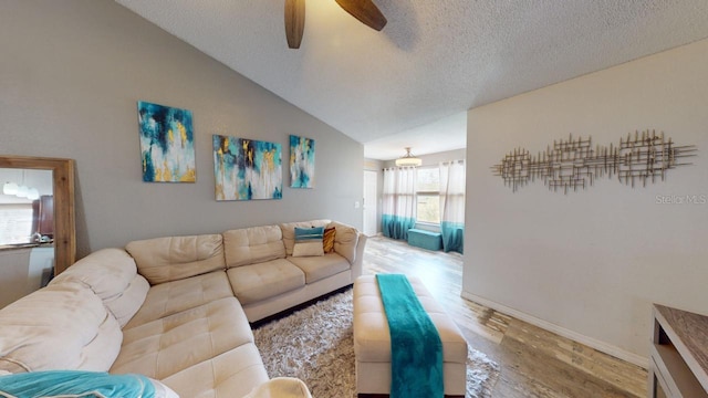 living room featuring wood-type flooring, a textured ceiling, vaulted ceiling, and ceiling fan