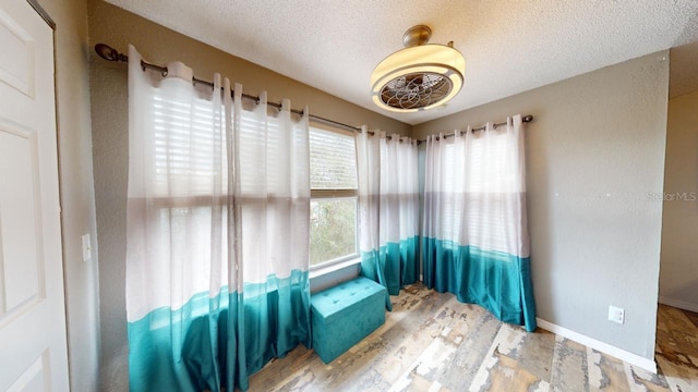 sitting room with a textured ceiling, light hardwood / wood-style floors, and a healthy amount of sunlight