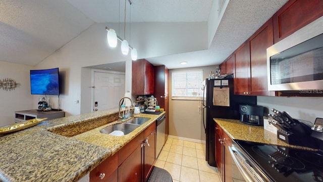 kitchen with lofted ceiling, sink, light stone countertops, appliances with stainless steel finishes, and decorative light fixtures