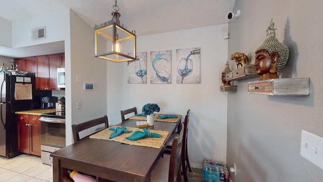 tiled dining area featuring a textured ceiling