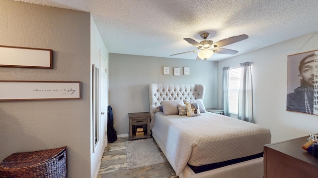 bedroom with ceiling fan and a textured ceiling