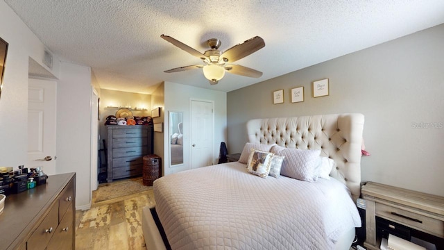 bedroom with a textured ceiling and ceiling fan