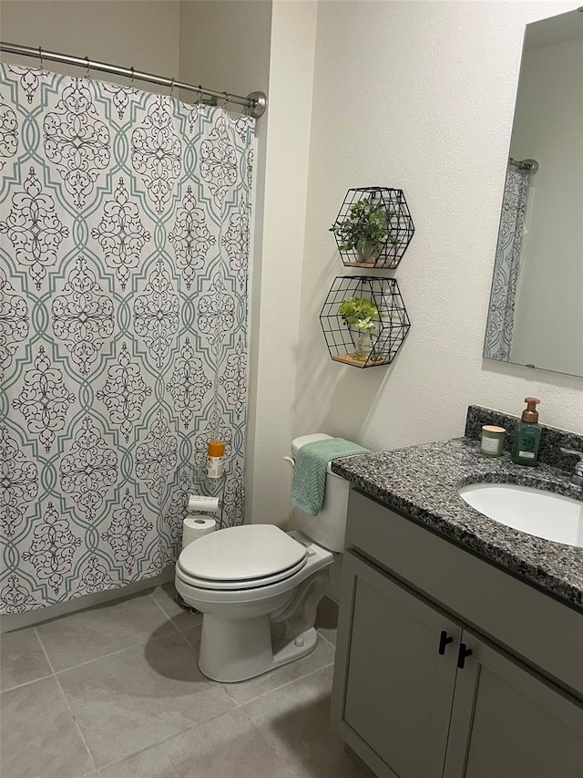 bathroom with tile patterned flooring, vanity, and toilet