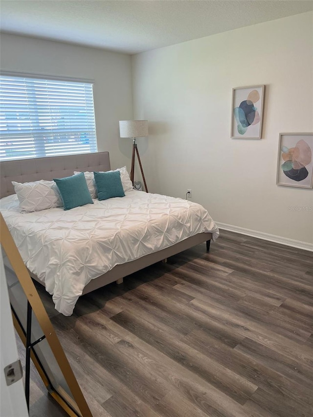 bedroom with dark wood-type flooring