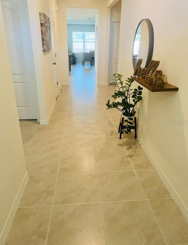 hallway featuring light tile patterned floors and baseboards