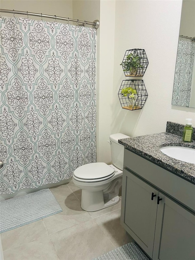 bathroom featuring tile patterned flooring, toilet, and vanity