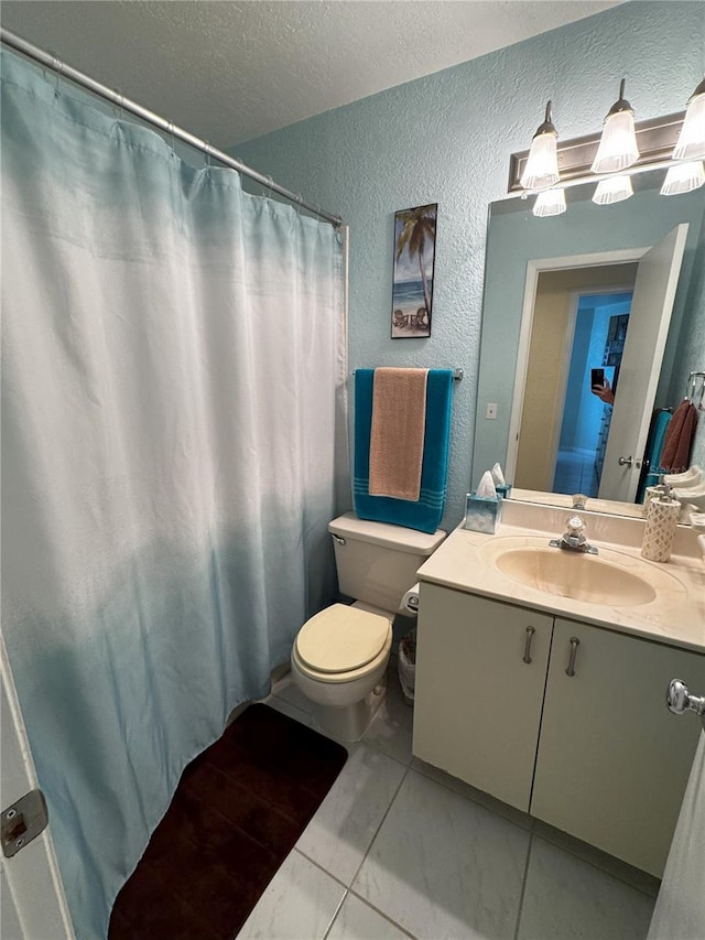 bathroom with tile patterned flooring, vanity, a textured ceiling, and toilet