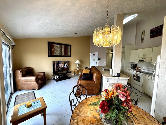 dining room with a textured ceiling, a notable chandelier, lofted ceiling, and sink