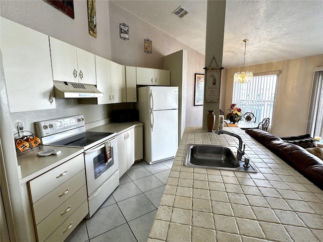 kitchen featuring a textured ceiling, white appliances, sink, a notable chandelier, and hanging light fixtures