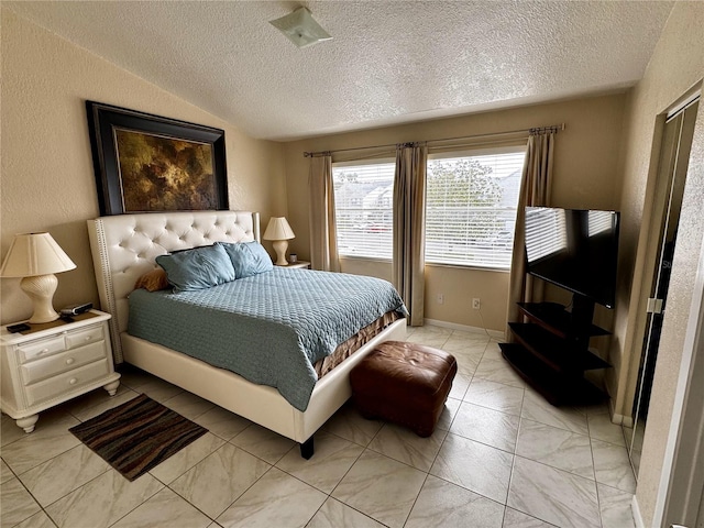 bedroom featuring a textured ceiling, light tile patterned flooring, and lofted ceiling