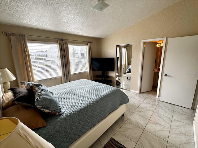 tiled bedroom featuring a textured ceiling and lofted ceiling