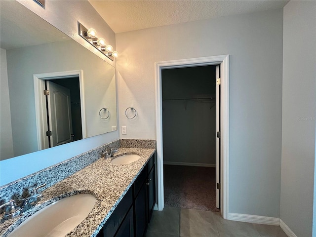 bathroom featuring tile patterned flooring, vanity, and a textured ceiling