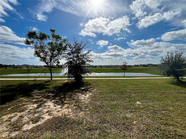 view of home's community featuring a water view and a lawn