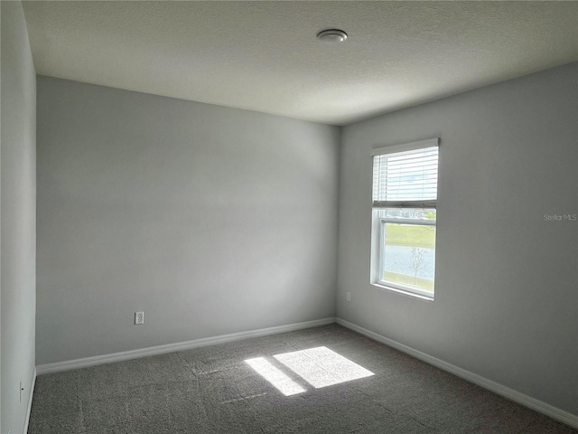 carpeted spare room featuring a textured ceiling