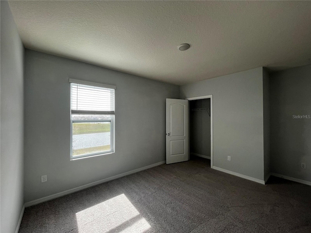 unfurnished bedroom with carpet floors, a textured ceiling, and a closet