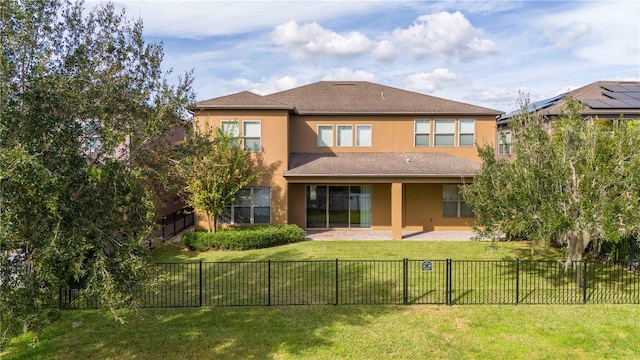 back of property with a lawn and a patio