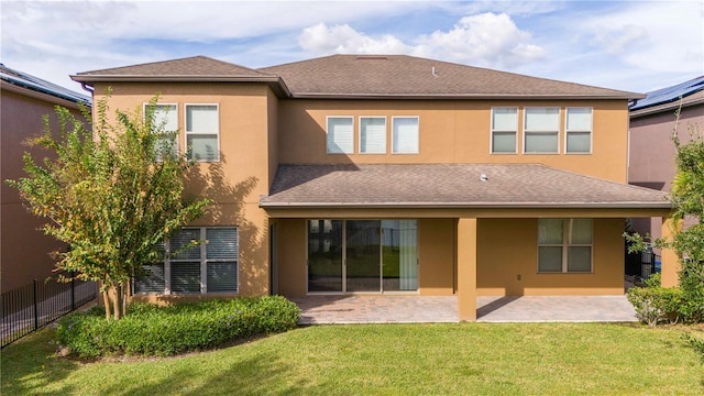 rear view of house featuring a lawn and a patio