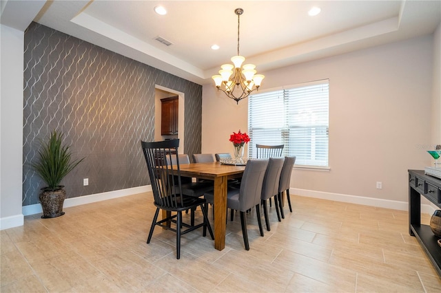 dining room featuring a raised ceiling and a chandelier