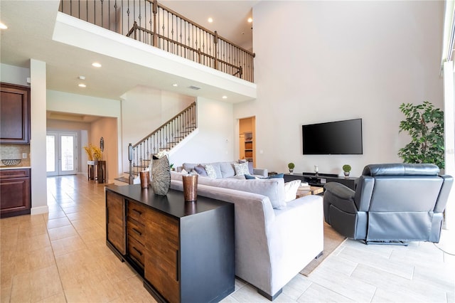 living room with light tile patterned flooring, french doors, and a high ceiling