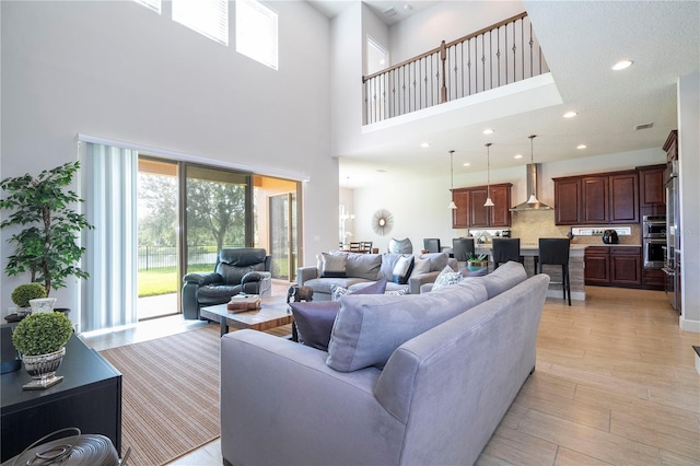 living room with a high ceiling and light hardwood / wood-style flooring