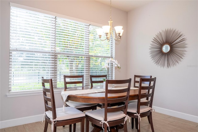 dining area with light wood-type flooring and a chandelier