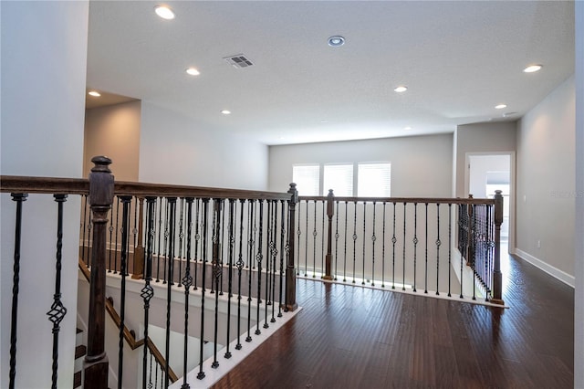 hallway featuring dark hardwood / wood-style floors and a textured ceiling