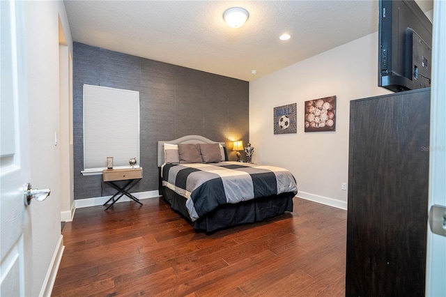 bedroom with a textured ceiling and dark wood-type flooring