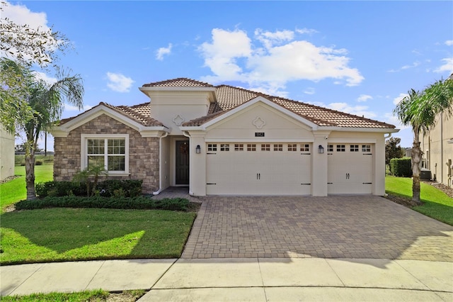 mediterranean / spanish home with cooling unit, a front yard, and a garage