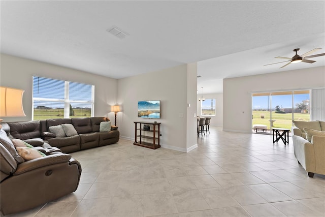 tiled living room featuring ceiling fan and a wealth of natural light