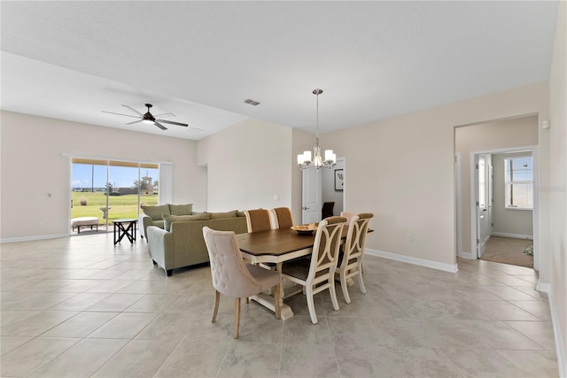 dining room featuring ceiling fan with notable chandelier, a wealth of natural light, and light tile patterned flooring