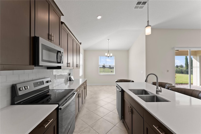 kitchen featuring a chandelier, pendant lighting, stainless steel appliances, and sink