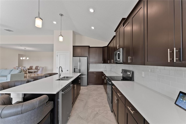 kitchen featuring sink, stainless steel appliances, pendant lighting, lofted ceiling, and decorative backsplash