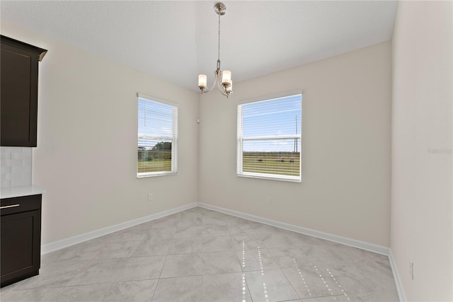 unfurnished dining area with an inviting chandelier