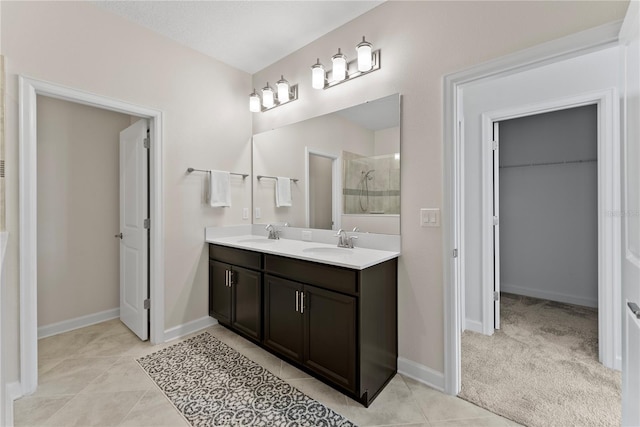 bathroom featuring a tile shower, tile patterned flooring, and vanity