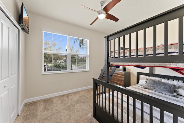 carpeted bedroom with ceiling fan and a closet