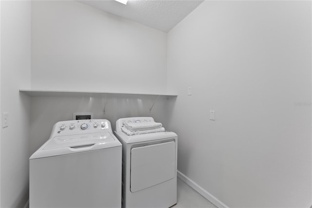 laundry room with washer and clothes dryer and a textured ceiling