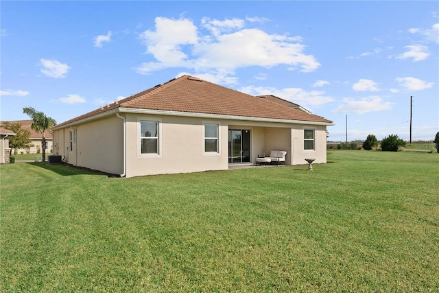 rear view of property with central AC and a lawn