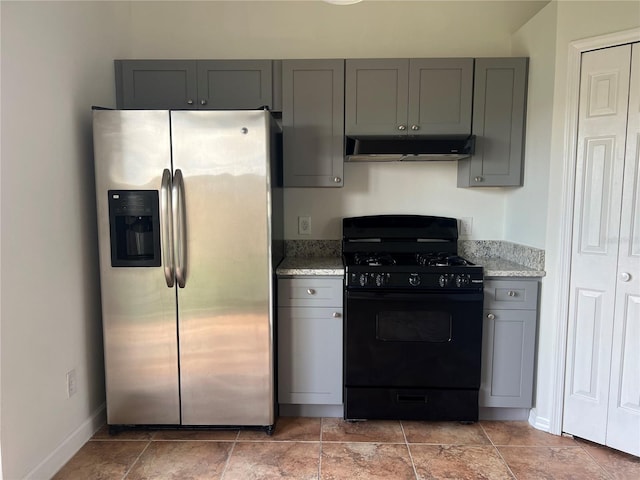 kitchen featuring light stone countertops, stainless steel refrigerator with ice dispenser, black gas range, and gray cabinets