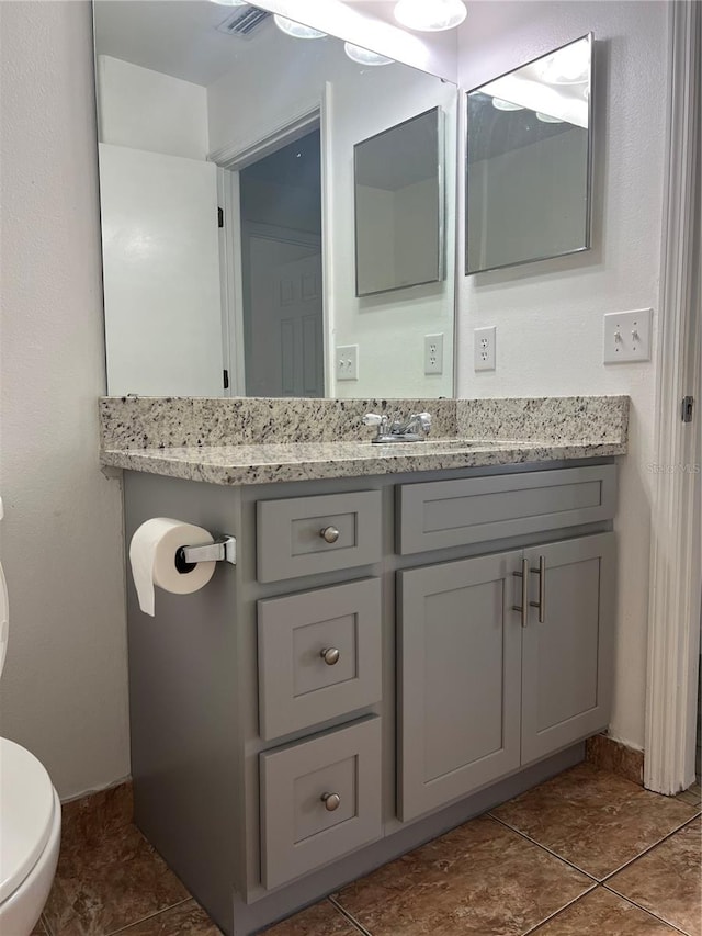 bathroom with tile patterned floors, vanity, and toilet