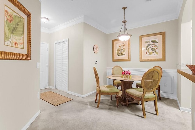 dining room with light colored carpet and ornamental molding