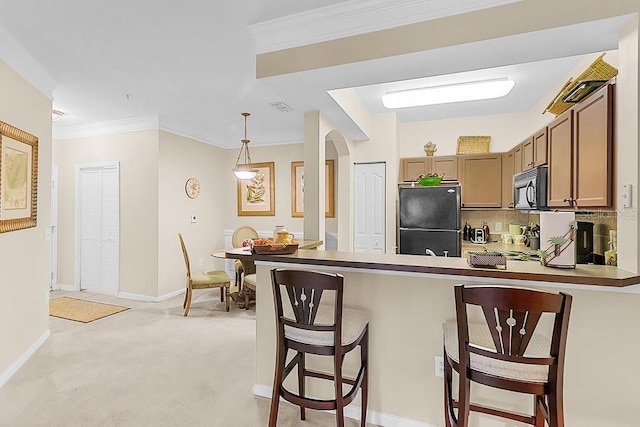 12843 Madison Pointe Cir Unit 107, Orlando, FL 32821 - kitchen with black appliances, a breakfast bar area, arched walkways, a peninsula, and ornamental molding